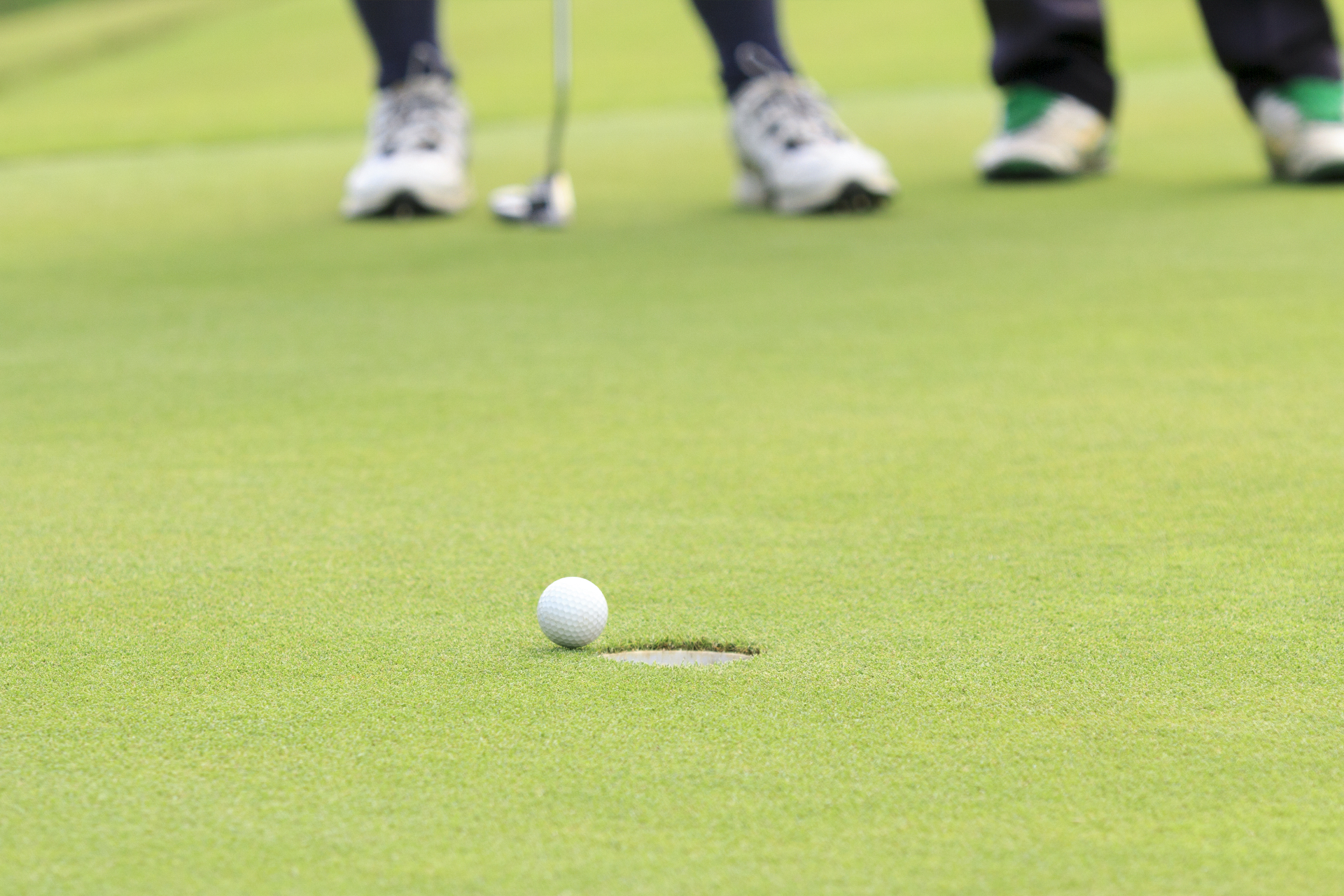 En boll rullar in i ett golfh&aring;l. 