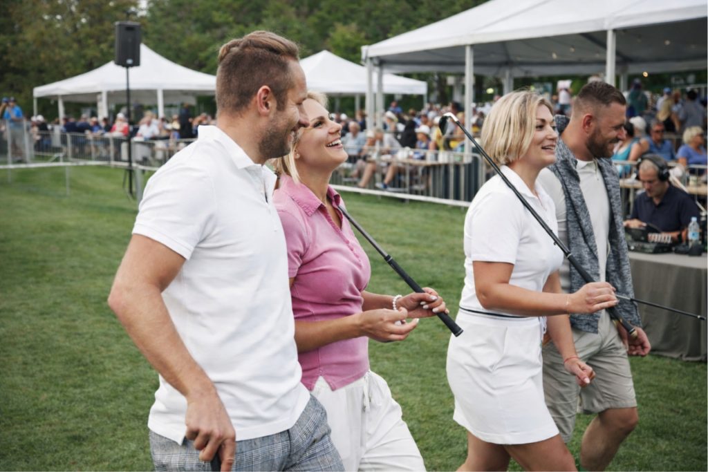 Speakerreklam på ett golfevent med publik.