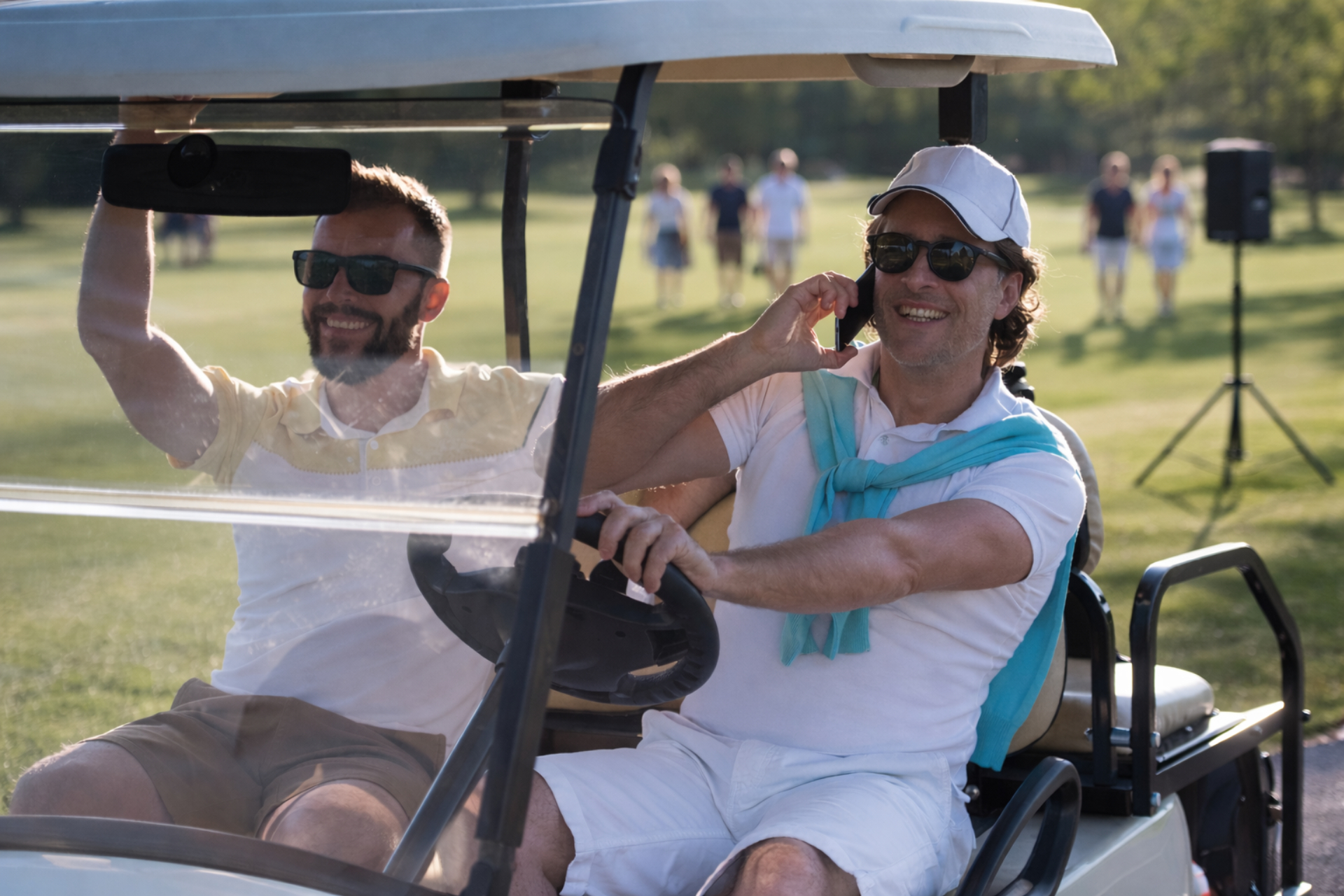 Två män i en golfbil på en golfbana